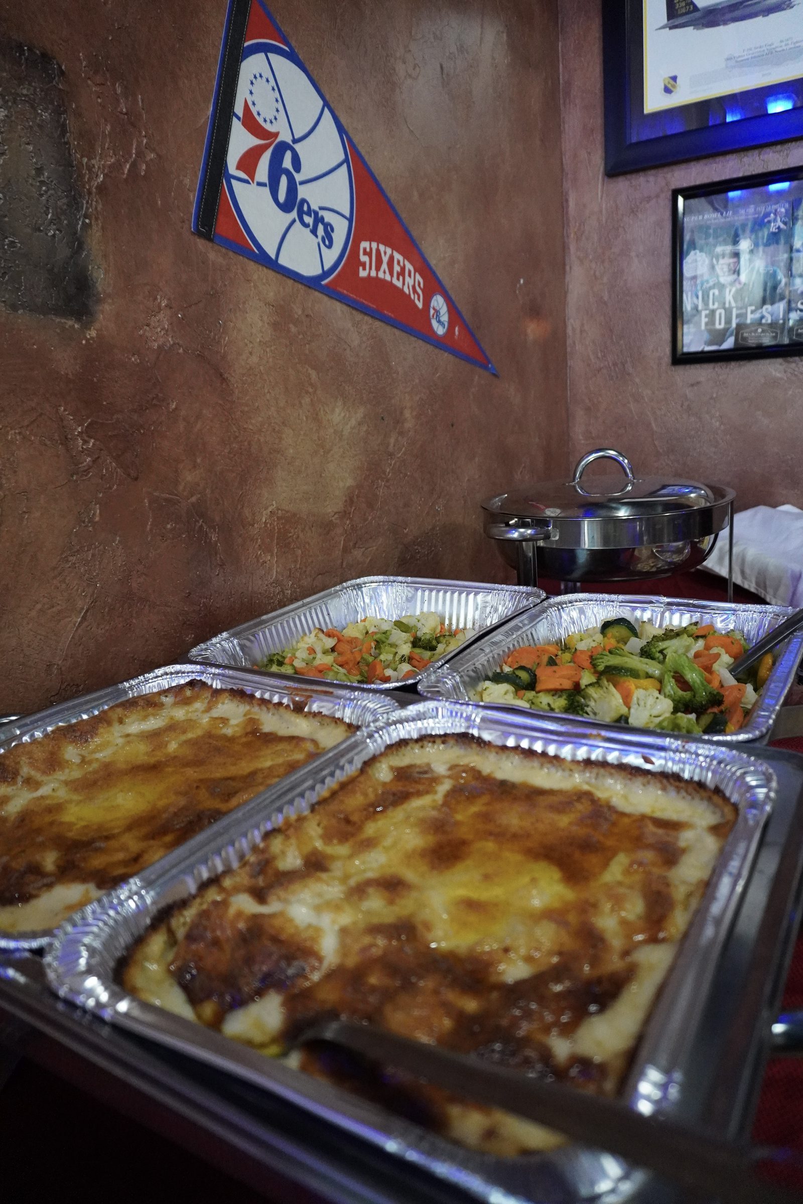Hot catering trays of baked pasta and roasted vegetables from Sak's Deli in Clayton NC