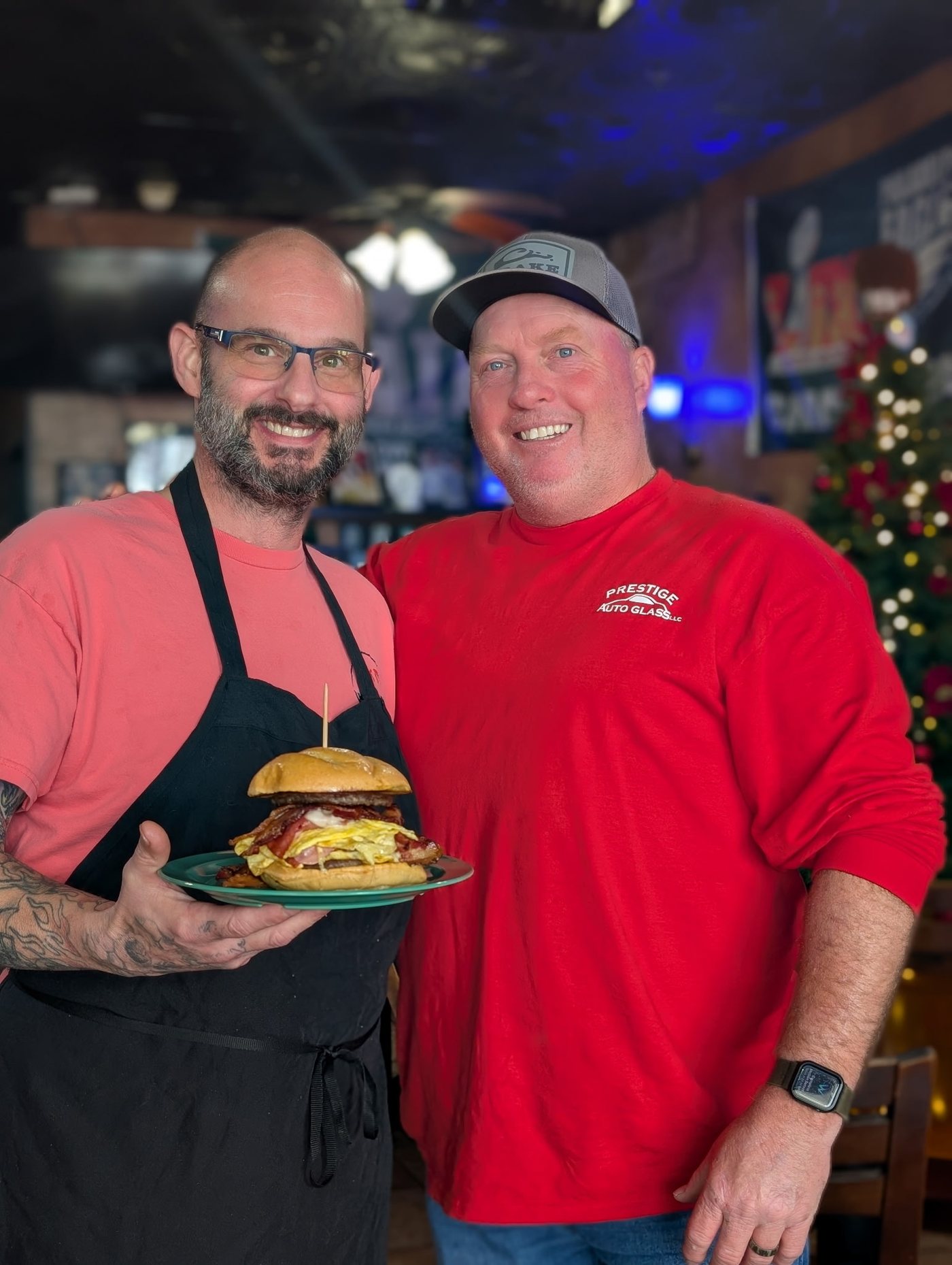 Matt and a happy regular with a loaded breakfast sandwich at Sak's Deli